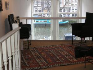 a room with a balcony with a view of the water at B&B Singel 100 in Amsterdam