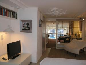 a living room with a flat screen tv and a couch at B&B Singel 100 in Amsterdam