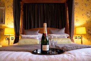 a bottle of wine sitting on top of a bed at Best Western Lichfield City Centre The George Hotel in Lichfield