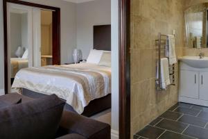 a hotel room with a large bed and a large mirror at Best Western Bradford Guide Post Hotel in Bradford