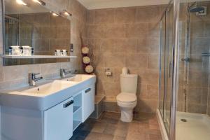 a bathroom with a toilet, sink, and shower at Best Western Lord Haldon Hotel in Exeter