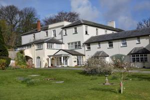 une grande maison blanche avec une grande cour dans l'établissement Best Western Lord Haldon Hotel, à Exeter