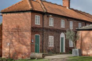 an old brick building with a green door and windows at Best Western Plus West Retford Hotel in Retford +103 photos