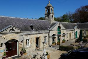 an old stone building with a clock tower at Normanton Park Hotel, BW Signature Collection in Oakham
