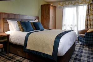 a hotel room with a large bed and a chair at Best Western Plus Pinewood Hotel, Manchester Airport South Handforth in Handforth +114 photos