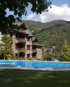 a house with a swimming pool and a blue sky at Abba Xalet Suites Hotel in Sispony