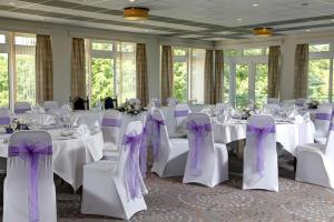 a room with white tables and chairs with purple bows at Best Western The Dartmouth Hotel, Golf & Spa in Dartmouth