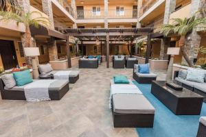 a lobby with couches and chairs and palm trees at City Express by Marriott Manhattan Beach in Manhattan Beach