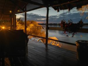 - une vue depuis la terrasse couverte d'une maison avec un lac dans l'établissement Caprivi Houseboat Safari Lodge, à Katima Mulilo
