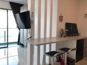 a living room with a table with a tv and stools at Heart of Bandar Baru Bangi (2) in Bangi