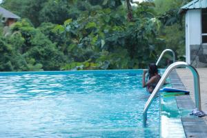 una mujer está en una piscina en Grindlays Regency en Ambepussa