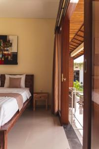 a bedroom with a bed and an open door at Umah Nugraha in Canggu