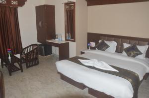 a bedroom with a bed and a table and a chair at Hotel Banaras Haveli in Varanasi