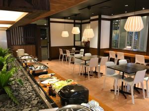 a restaurant with tables and chairs with food on them at Hotel First Stay Amagasaki in Amagasaki