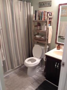 a bathroom with a shower curtain and a toilet and a sink at 'It's All Good!' in Corpus Christi