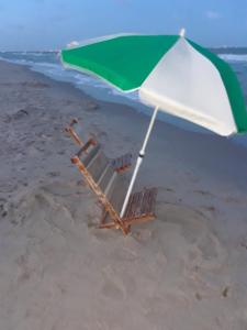 una silla de playa y una sombrilla en la playa en 'It's All Good!', en Corpus Christi