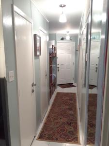 a hallway with white doors and a rug at 'It's All Good!' in Corpus Christi