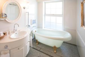 a bathroom with a tub and a sink and a mirror at Kobe Kitano Hotel in Kobe +80 photos