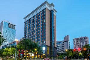 un edificio alto en una ciudad por la noche en Foshan Rezen Select Pasonda Hotel, en Foshan