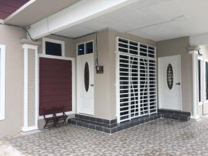 una porta d'ingresso di una casa con garage di Aina Guest House a Kota Bharu