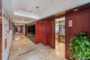 a hallway of a building with a door and a plant at Foshan Rezen Select Pasonda Hotel in Foshan