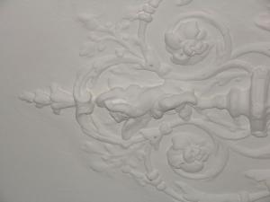 a white wall with a carving of flowers on it at B&B Singel 100 in Amsterdam