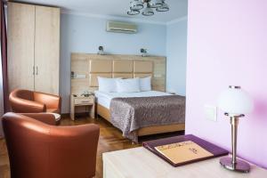 1 dormitorio con 1 cama y escritorio con silla en Hotel Krasnoyarsk, en Krasnoyarsk