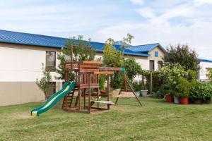 a playground with a slide and a swing at Days Inn by Wyndham Jacksonville in Jacksonville