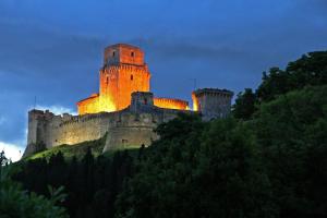 un castello in cima a una collina di notte di IL TURRIONE "app. Santa Chiara" ad Assisi