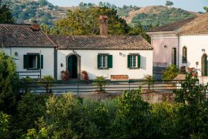 ein weißes Haus mit grünen Rollläden in einem Dorf in der Unterkunft Casa Vacanze Etna in Piedimonte Etneo