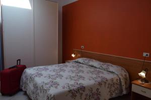 a bedroom with a bed and a red suitcase at IL TURRIONE "app. Santa Chiara" in Assisi