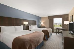 a hotel room with two beds and a television at Days Inn by Wyndham Stephenville in Stephenville +42 photos