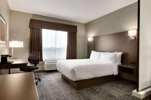 a hotel room with a bed and a window at Days Inn & Suites by Wyndham Warman in Warman +75 photos