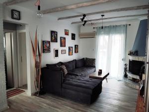 a living room with a black couch and a fireplace at You can almost smell the sea! in Athens