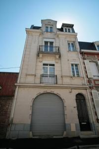 wysoki budynek z drzwiami garażowymi i bramą w obiekcie Comme à la Maison - DE LA TOUR w mieście Saint-Quentin