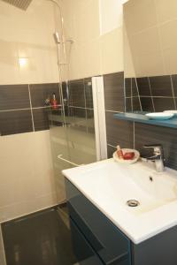 a bathroom with a sink and a shower at Comme à la Maison - DE LA TOUR in Saint-Quentin +25 photos