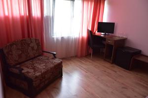 a living room with a chair and a desk with a computer at Green Hill Hotel in Stara Zagora