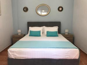 a bedroom with a large bed with two blue pillows at Katerina's Apartment in Toroni