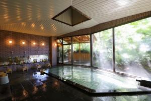 una piscina en una habitación con una ventana grande en Hotel Shirakabaso Shigakogen, en Yamanouchi