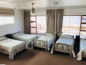 a bedroom with three beds and a window at 39 Kabeljauws Road Beach House in Jeffreys Bay