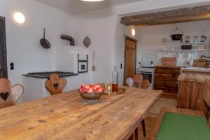 a kitchen with a wooden table with a bowl of apples at Obiralmhütte Fladung in Bad Eisenkappel