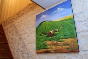 a painting of a green field on a wall at La Pousada in Dormans