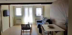 salon z kanapą i stołem w obiekcie Apartamentos-Bermeo w mieście Bermeo