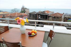 a table with a vase of flowers and fruit on a balcony at Aycan Sultan Apart Hotel in Istanbul