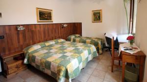 1 dormitorio con 2 camas, mesa y escritorio en Albergo Santo Spirito, en Molini di Triora