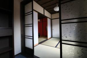 a mirror in a room with a red door at Daisenji Lodge Ing 紅 地下鉄鞍馬口駅から徒歩1分 in Kyoto