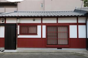 un edificio rojo y blanco con puertas rojas en Daisenji Lodge Ing 紅 地下鉄鞍馬口駅から徒歩1分, en Kioto