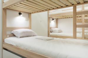 a bedroom with two bunk beds and a mirror at Gravitas Hostel in Split