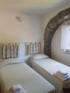 皮尼奧內的住宿－Villaggio Fiorito Casale，两张睡床彼此相邻,位于一个房间里