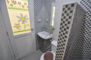a bathroom with a sink and a toilet and a mirror at Duangjai Residence - SHA Extra Plus in Rawai Beach
